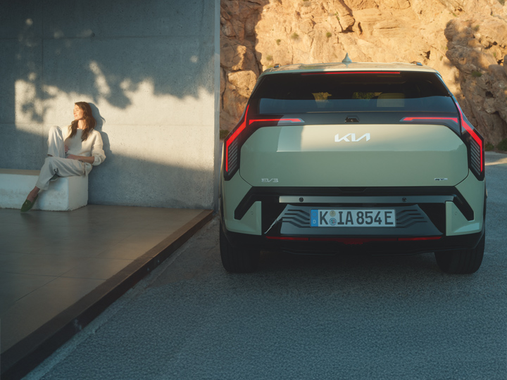 Kia EV3 Rückansicht mit Model zur linken Seite - Kia Sommerangebote 2025
